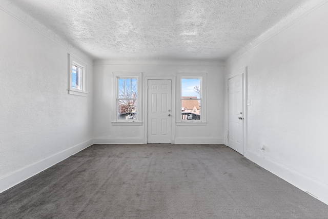 carpeted empty room featuring a textured ceiling