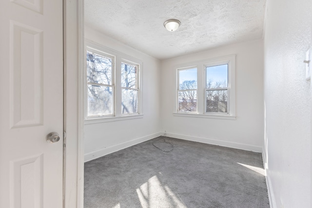 carpeted empty room with a textured ceiling