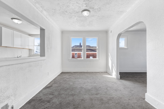 carpeted empty room with a textured ceiling