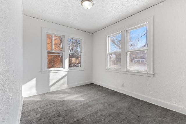 carpeted empty room with a textured ceiling