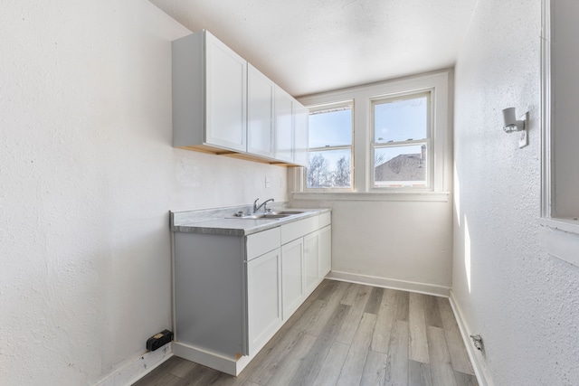 washroom with sink and light hardwood / wood-style flooring