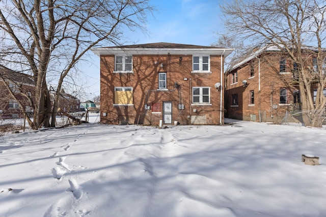 view of snow covered back of property