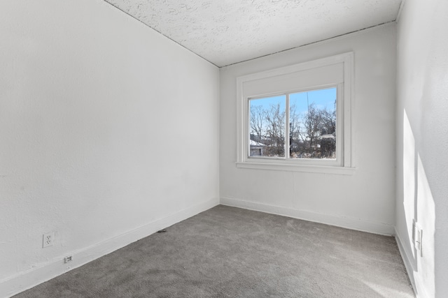 carpeted spare room with a textured ceiling