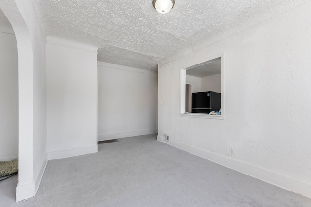 carpeted spare room with a textured ceiling