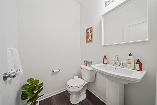 bathroom with hardwood / wood-style flooring and toilet