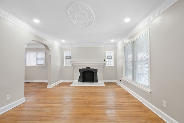 unfurnished living room with crown molding and light hardwood / wood-style floors