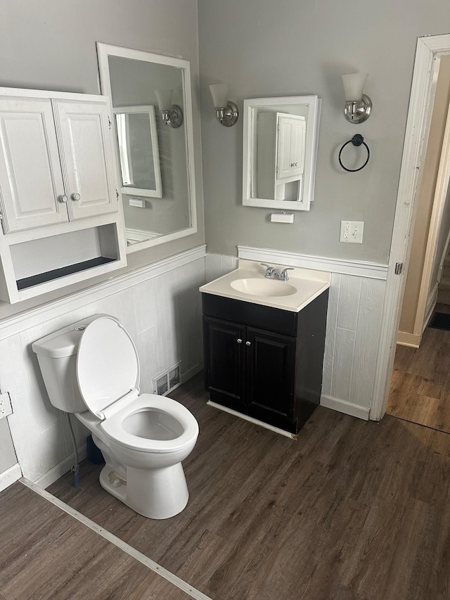 bathroom with wood-type flooring, vanity, and toilet