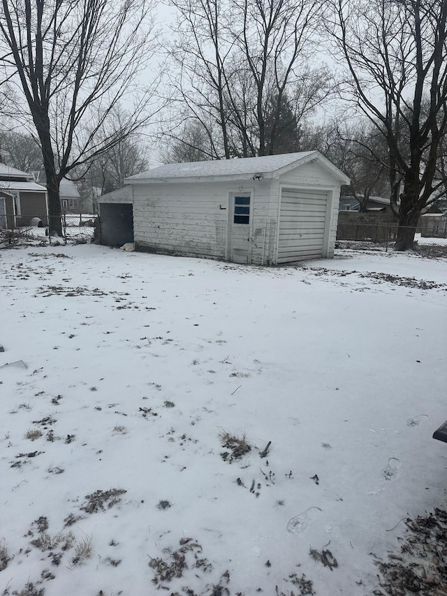 snow covered structure with a garage