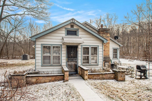 bungalow featuring a shed