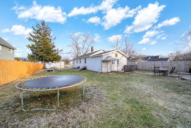 view of yard with a playground and a trampoline