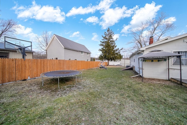 view of yard featuring a playground, a gazebo, and a trampoline