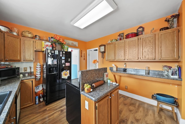 kitchen featuring dark hardwood / wood-style flooring, black fridge with ice dispenser, and sink