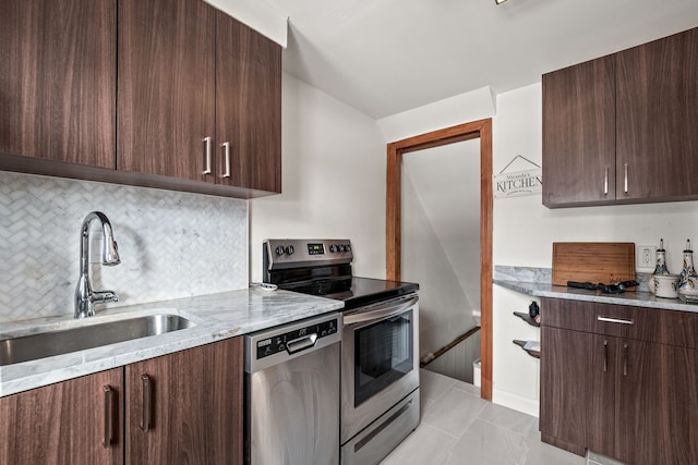 kitchen with stainless steel appliances, dark brown cabinets, sink, and light stone counters