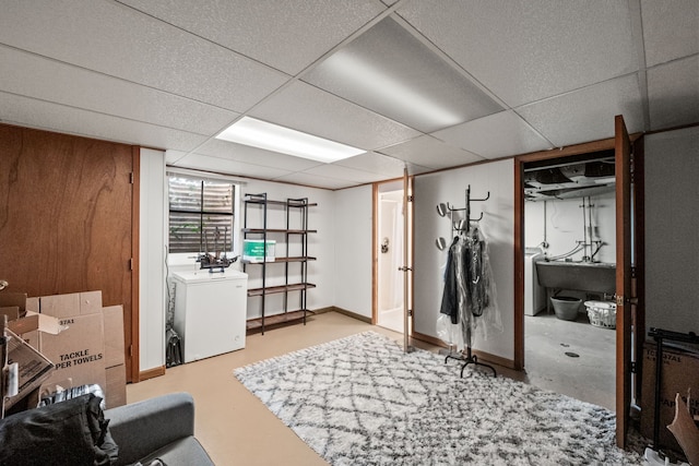 interior space with washer / clothes dryer, a paneled ceiling, and sink