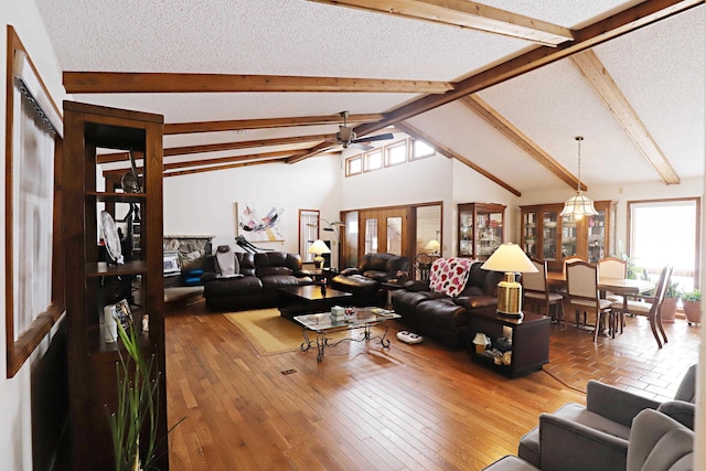 living room featuring hardwood / wood-style flooring, a textured ceiling, and beamed ceiling