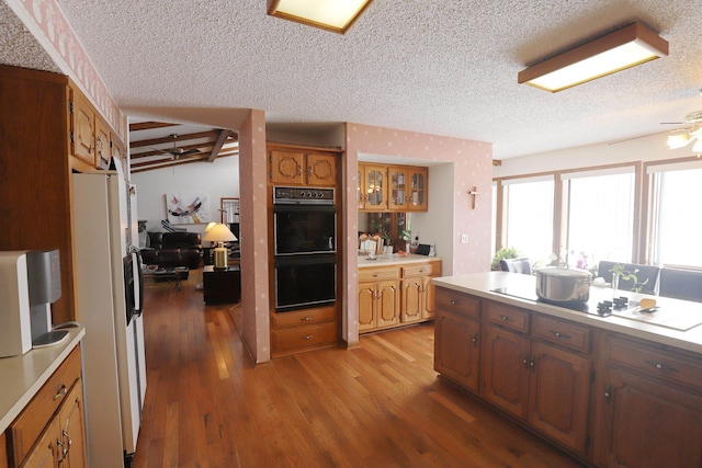 kitchen with ceiling fan, light hardwood / wood-style floors, a textured ceiling, and white refrigerator