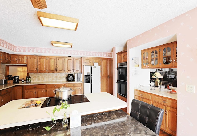 kitchen featuring brown cabinets, light countertops, and black appliances