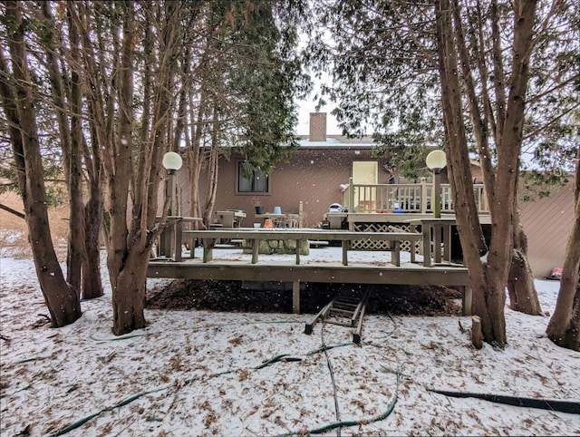 snow covered property featuring a chimney and a deck