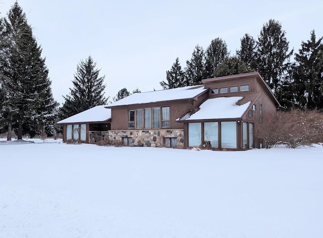 snow covered house featuring a garage