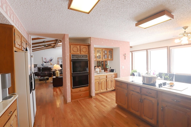 kitchen with brown cabinetry, light countertops, light wood-type flooring, white fridge with ice dispenser, and a warming drawer