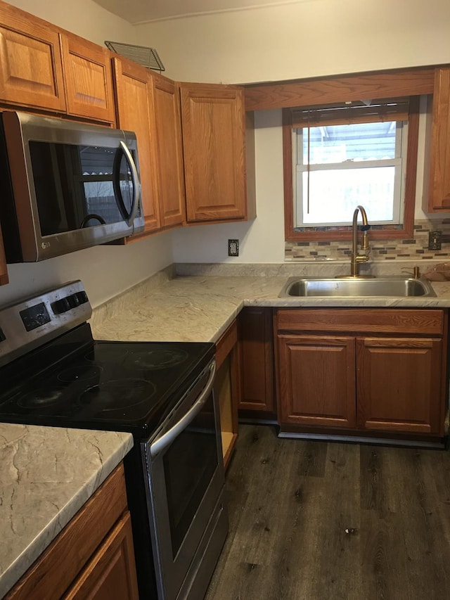 kitchen with stainless steel appliances, dark hardwood / wood-style floors, sink, and backsplash