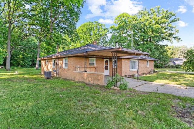1408 Stephens Ave, Flint, MI 48507 - view of front of house featuring brick siding, a front lawn, a chimney, a carport, and asphalt driveway