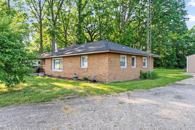 1408 Stephens Ave, Flint, MI 48507 - view of property exterior featuring brick siding, a lawn, roof with shingles, and a chimney