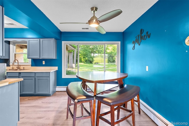 1408 Stephens Ave, Flint, MI 48507 - dining space featuring baseboard heating, ceiling fan, and light wood-style floors
