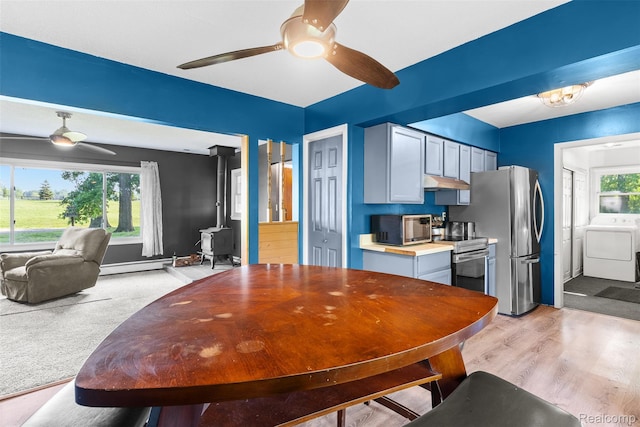 1408 Stephens Ave, Flint, MI 48507 - dining area with ceiling fan, washer and dryer, a baseboard heating unit, and light wood finished floors