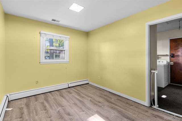 1408 Stephens Ave, Flint, MI 48507 - empty room featuring wood finished floors, a baseboard heating unit, and washer / clothes dryer