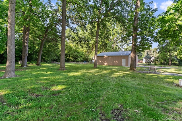 1408 Stephens Ave, Flint, MI 48507 - view of green lawn featuring an outbuilding, an outdoor structure, and view of wooded area