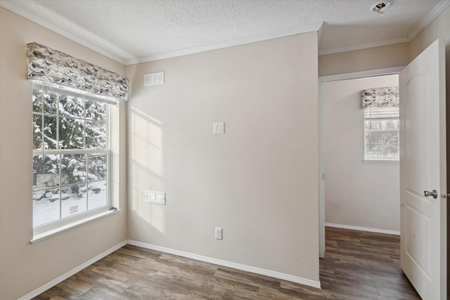 spare room with crown molding, dark hardwood / wood-style flooring, and a textured ceiling