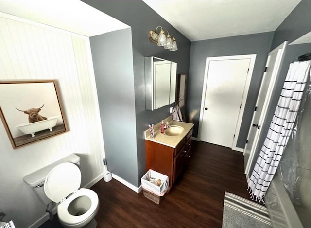 bathroom with wood-type flooring, a shower with shower curtain, vanity, and toilet