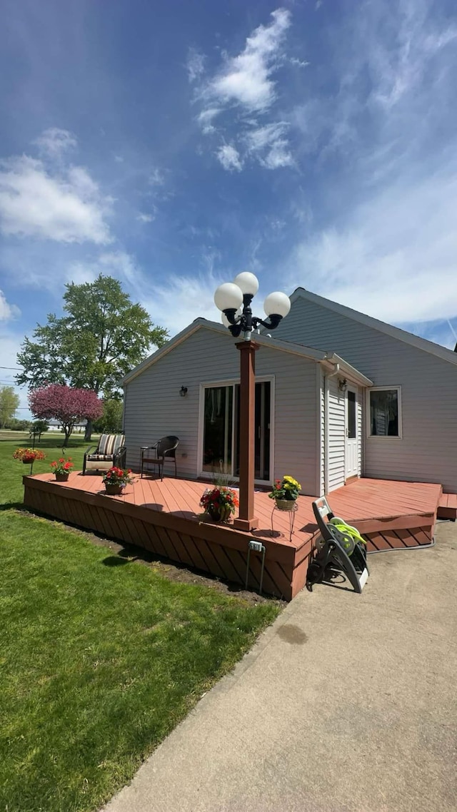 rear view of house with a yard and a deck