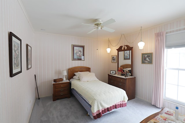 bedroom with ceiling fan, ornamental molding, dark carpet, and multiple windows