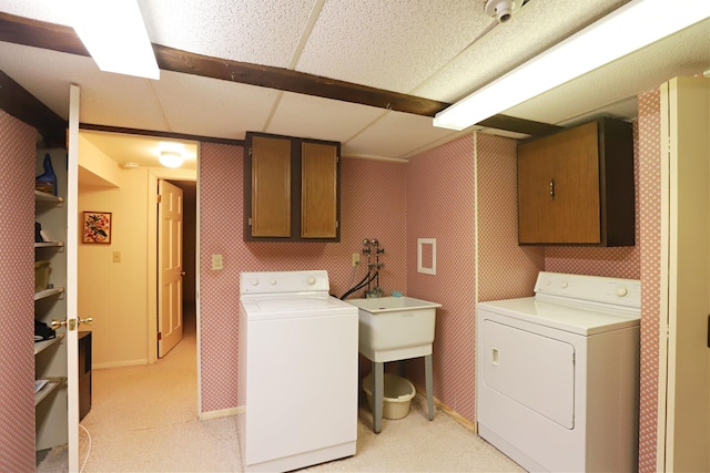 laundry area featuring cabinets, separate washer and dryer, and light carpet