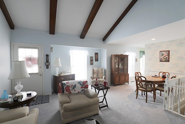 carpeted living room with lofted ceiling with beams