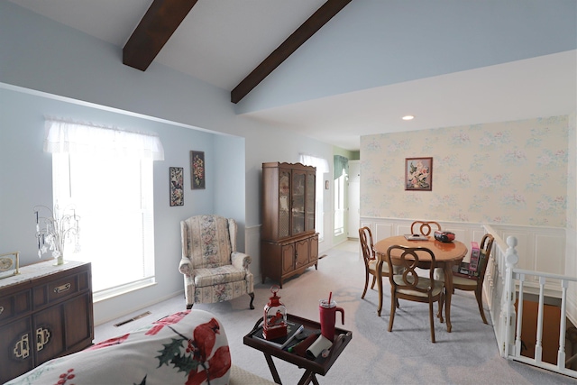 carpeted living room featuring lofted ceiling with beams