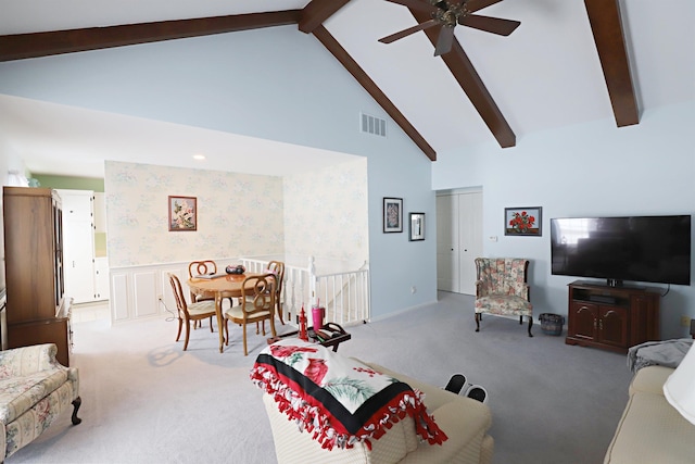 carpeted living room with beamed ceiling, ceiling fan, and high vaulted ceiling