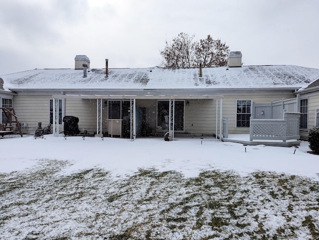 view of snow covered back of property