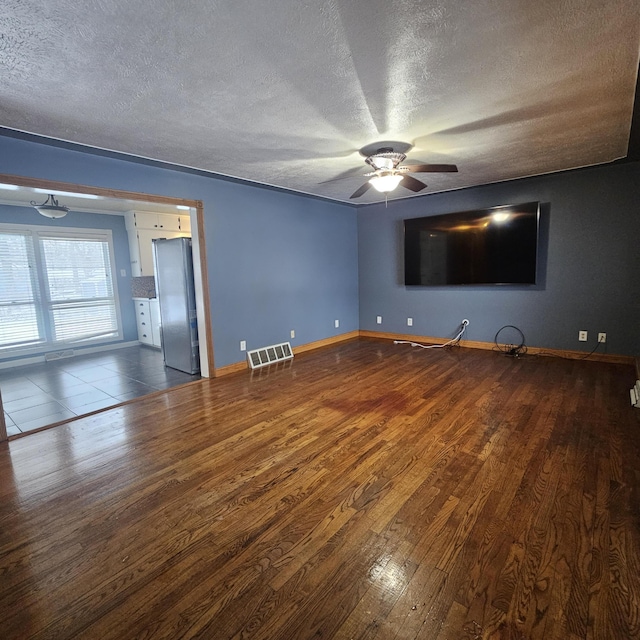 empty room featuring hardwood / wood-style floors, a textured ceiling, and ceiling fan