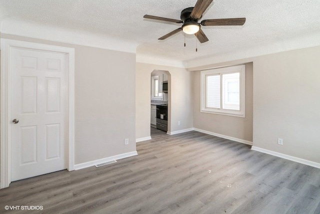 interior space featuring ceiling fan, wood-type flooring, and a textured ceiling