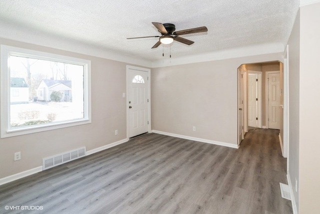 entryway with ceiling fan, dark wood-type flooring, and a textured ceiling