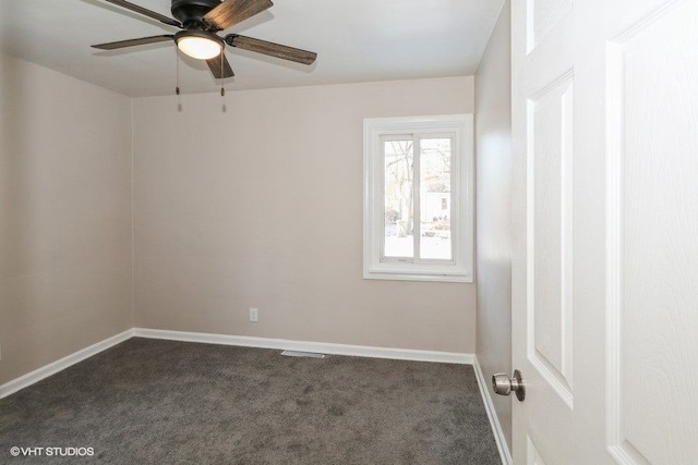 spare room featuring ceiling fan and dark carpet