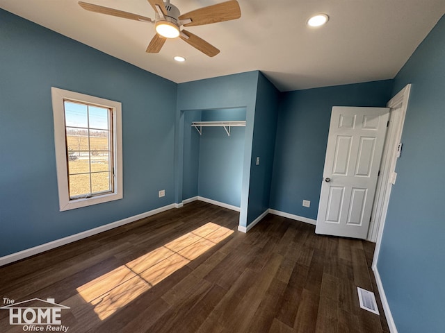 unfurnished bedroom with ceiling fan, dark hardwood / wood-style flooring, and a closet