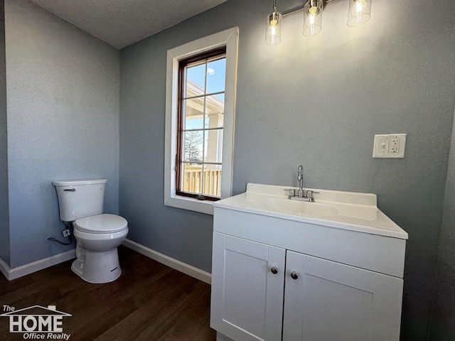 bathroom featuring vanity, wood-type flooring, and toilet