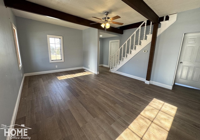 unfurnished room featuring dark wood-type flooring, ceiling fan, beam ceiling, and a textured ceiling