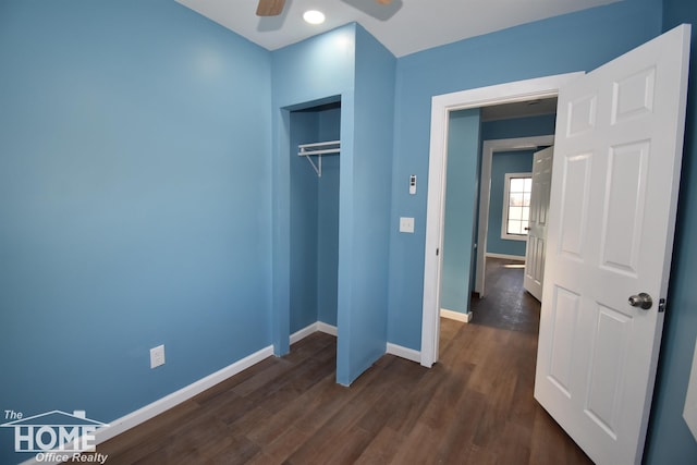 unfurnished bedroom with ceiling fan, dark hardwood / wood-style flooring, and a closet