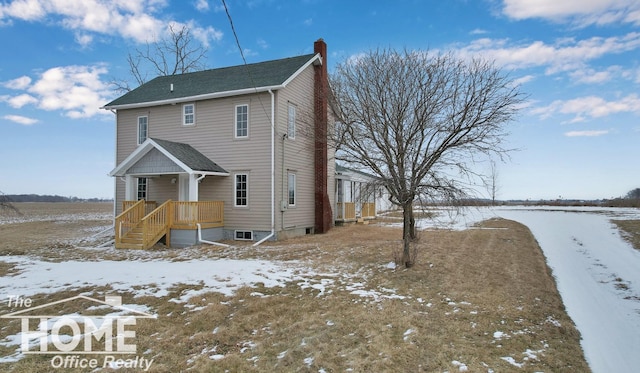 view of snow covered rear of property