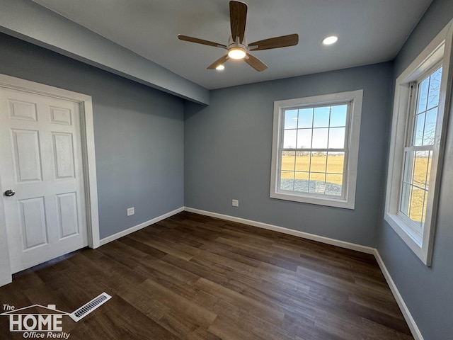 empty room with ceiling fan and dark hardwood / wood-style flooring